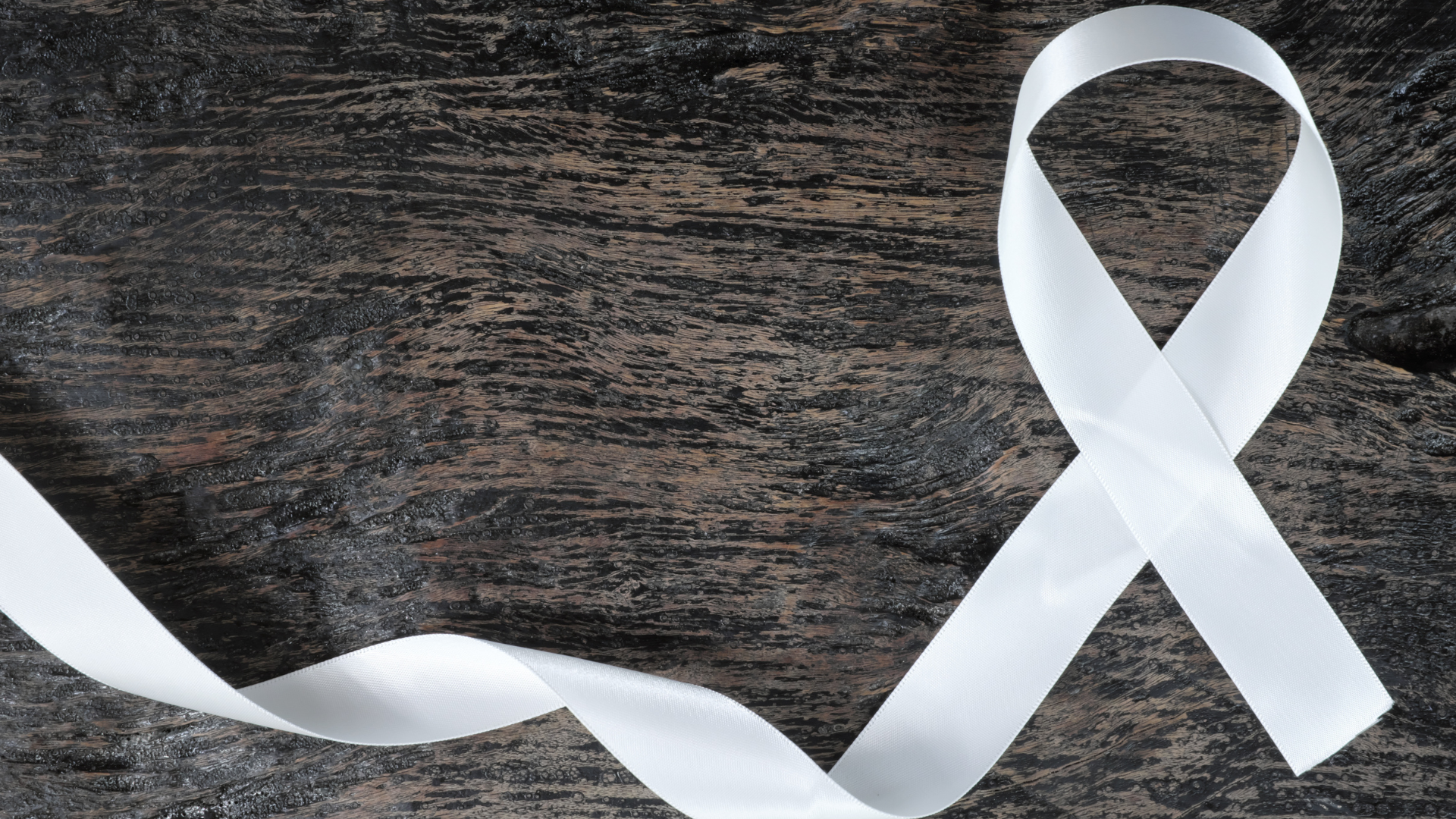 white cancer awareness ribbon on wood background